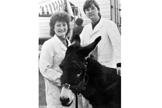 Newton Abbot Christmas Show from December 1984. Vice chairman of Newton Abbot Young Farmers Heather Slade with John Bellamy who were encouraging visitors to that year’s show to guess the weight of the donkey. (Editor’s note:  And no, we don’t know what the weight was)