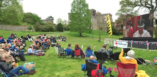 Crowds at Powderham Castle watch the coronation of King Charles III