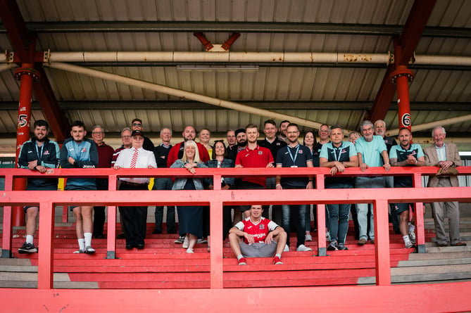 Staff and volunteers from Exeter City Football Club gather at St James Park to celebrate winning a gold award for family excellence.