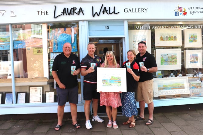 Laura Wall and representatives from Teignmouth Rugby Club pose with the Seaside Scrum print and pint cups