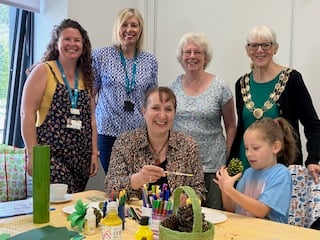 Attendees at the Bovey Tracey World FairTrade Day event making pineapples out of pine cones