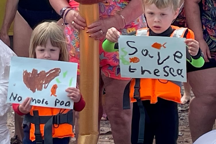 Children hold placards at the Teignmouth protest against sewage pollution.