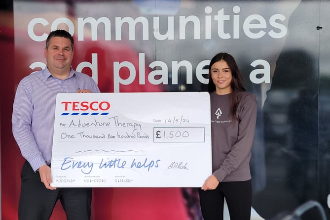 James Sanders, store manager at Tesco’s Newton Abbot Superstore, presents the £1,500 cheque to Adventure Therapy’s Amy Weekes