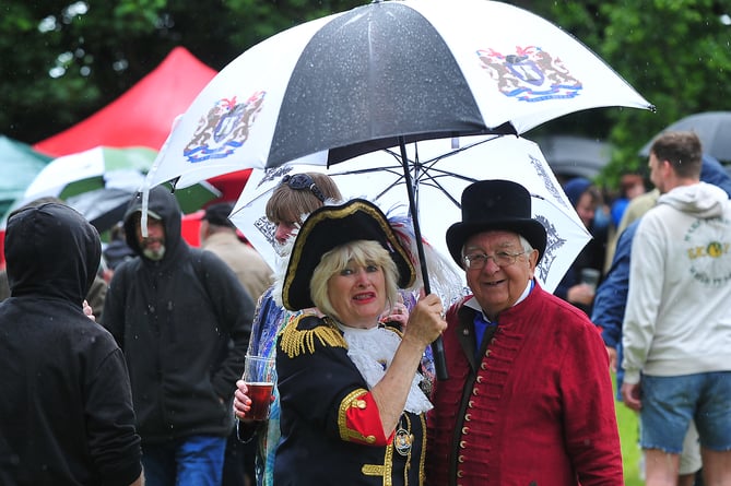 Kingsteignton Ram Roast Fair. Avoiding the showers - Kingsteignton Town Crier Jackie Edwards and Crier's Consort John Hart
