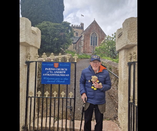 Retired vicar Marcus Braybrook with his RNLI teddy outside Stokeinteignhead Parish Church