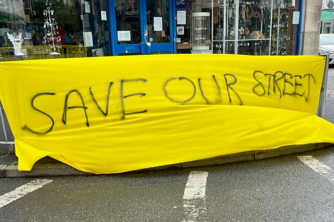 A Save Our Street banner waves on the corner of Queen Street and Courtenay Street in Newton Abbot