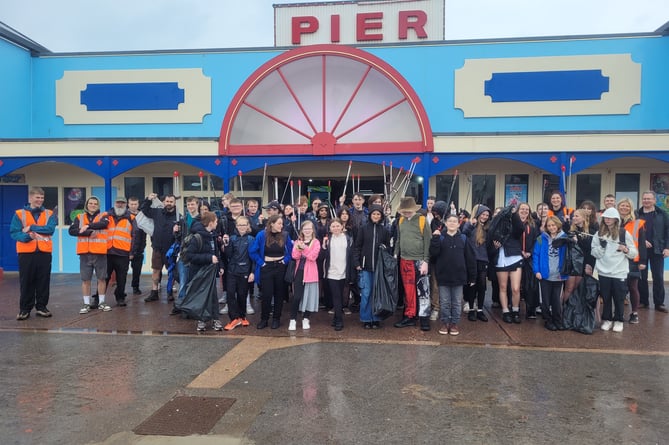 Students from Teignmouth Community School gathered by the pier after cleaning up the beach