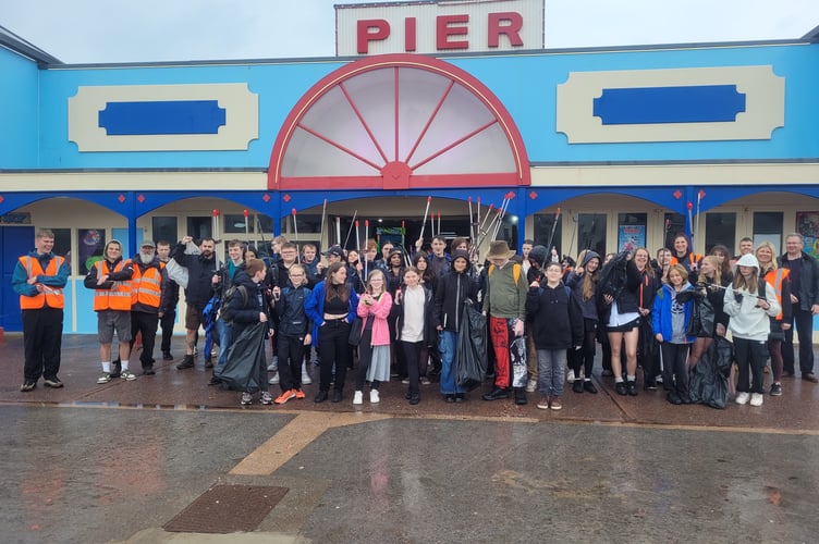 Students from Teignmouth Community School gathered by the pier after cleaning up the beach