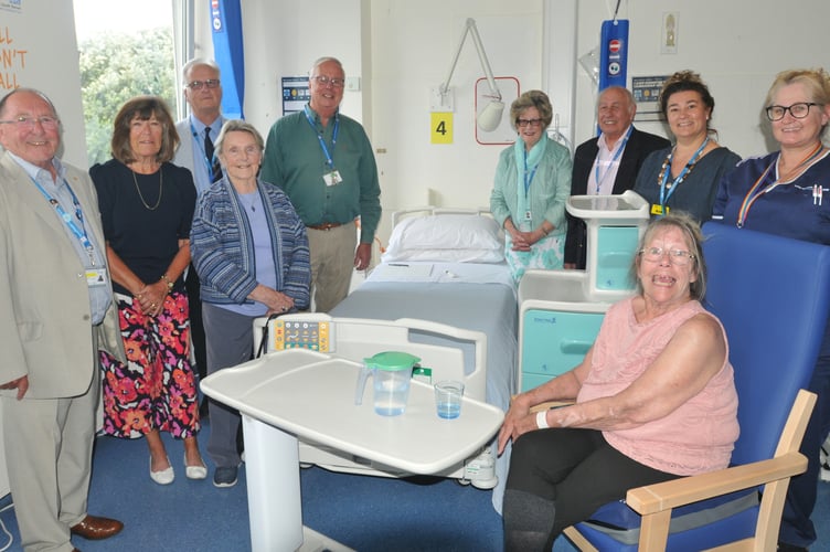 Pictured from left are League of Friends members Roy Tuttle, Julia Hearne, Martin Tucker, Patricia Roberts, Philip White, Lynne Hookings, Michael Hookings, along with Anke Scholey (Operation Manager Inpatient Discharge), Leonie Price (Ward Manager). Seated: Sharon Valentine (Patient awaiting discharg