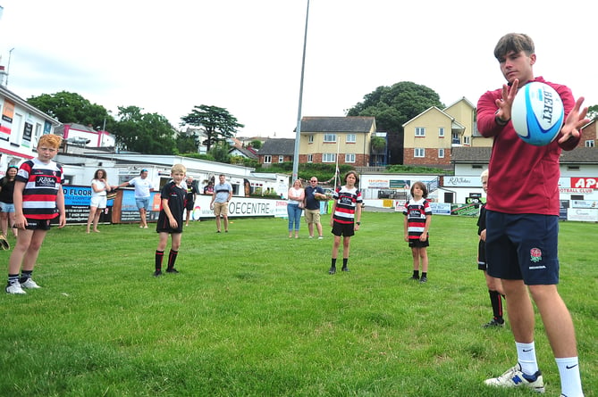 Ben Coen, of England's  Under-20 World Rugby Championship winning team, with young members of Teignmouth Rugby Club