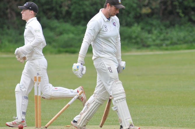 Devon Cricket League A  Division. Torquay and Kingskerswell versus Bridestowe. Chris Kelmere walks after being bowled by Bridestowe's Craig Penberthy while 'keeper Patrick Ewen heads down pitch to join the celebrations