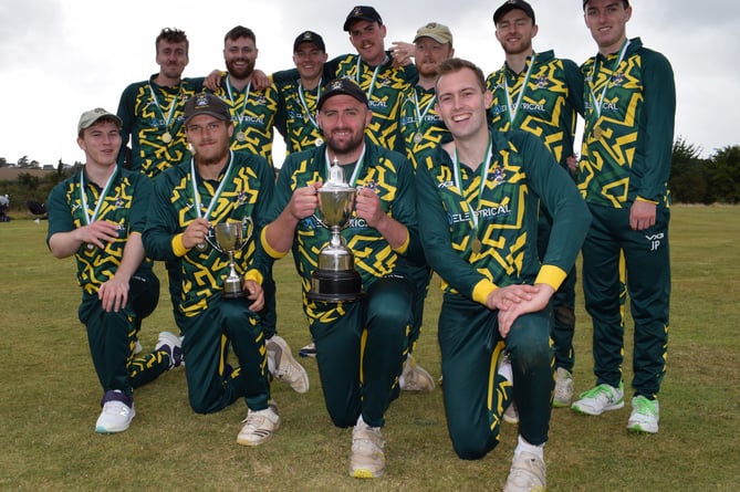 Bovey Tracey captain Dan Green shows off the Aaron Printers Cup after his side's 11-run win over Torquay in the final at Stokeinteignhead