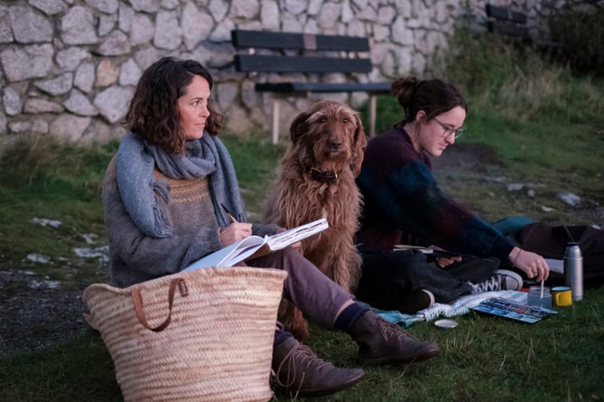 Two ladies sketching with their dog as part of a StreetDraw 24 event