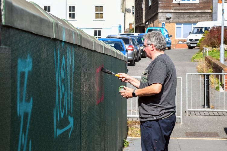 David Cox cleaning up a pedestrian bridge over the railway in Teignmouth