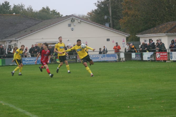 Myles Smiths prepares to clear the ball against Brixham