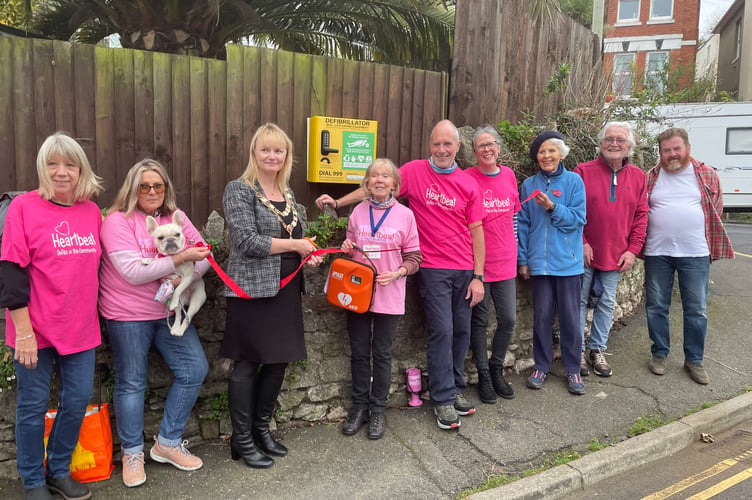 L-R Janet Roberts, Liz Kossifos, Teignmouth Mayor Cllr Cate Williams, Teign Heartbeat founder and chair Shirley Brokenshaw, Mark Hollingsworth, Lucie Hollingsworth, Anna Perry, Teignmouth Chamber of Commerce chair Keith Underhill and Tom Dunne who fitted the defibrillator to the fence of his property.