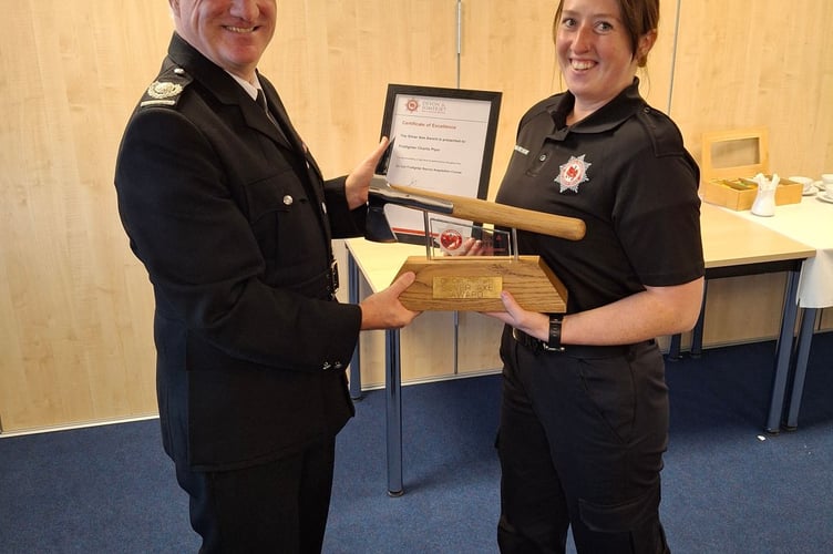 Devon and Somerset Fire and Rescue area manager Wayne Rawlins presents Newton Abbot new recruit Charlie Plyer with the silver axe award